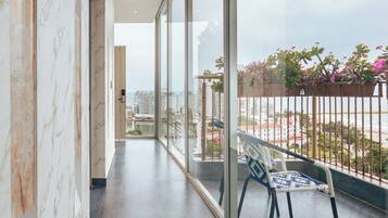 A spacious balcony with a view of the cityscape and beach.