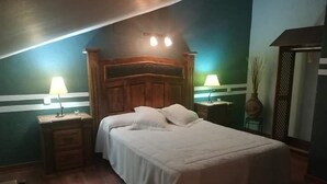 A bedroom with a wooden headboard, two bedside tables with lamps, a bed with white bedding, and a wooden floor. - Hostal la Cerca (Arcones)
