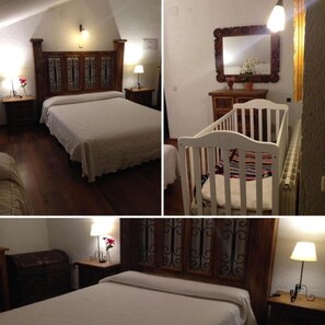 A cozy bedroom with two beds, a crib, a wooden headboard, a mirror, and a nightstand with a lamp. - Hostal la Cerca (Arcones)