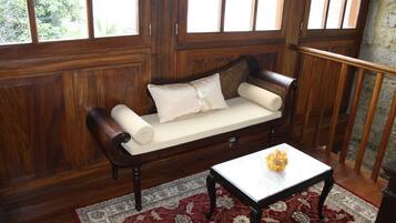 A wooden-paneled room with a wooden bench and a small table with a vase.