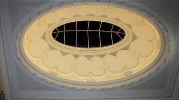A ceiling with an ornate, circular window with a grid pattern.