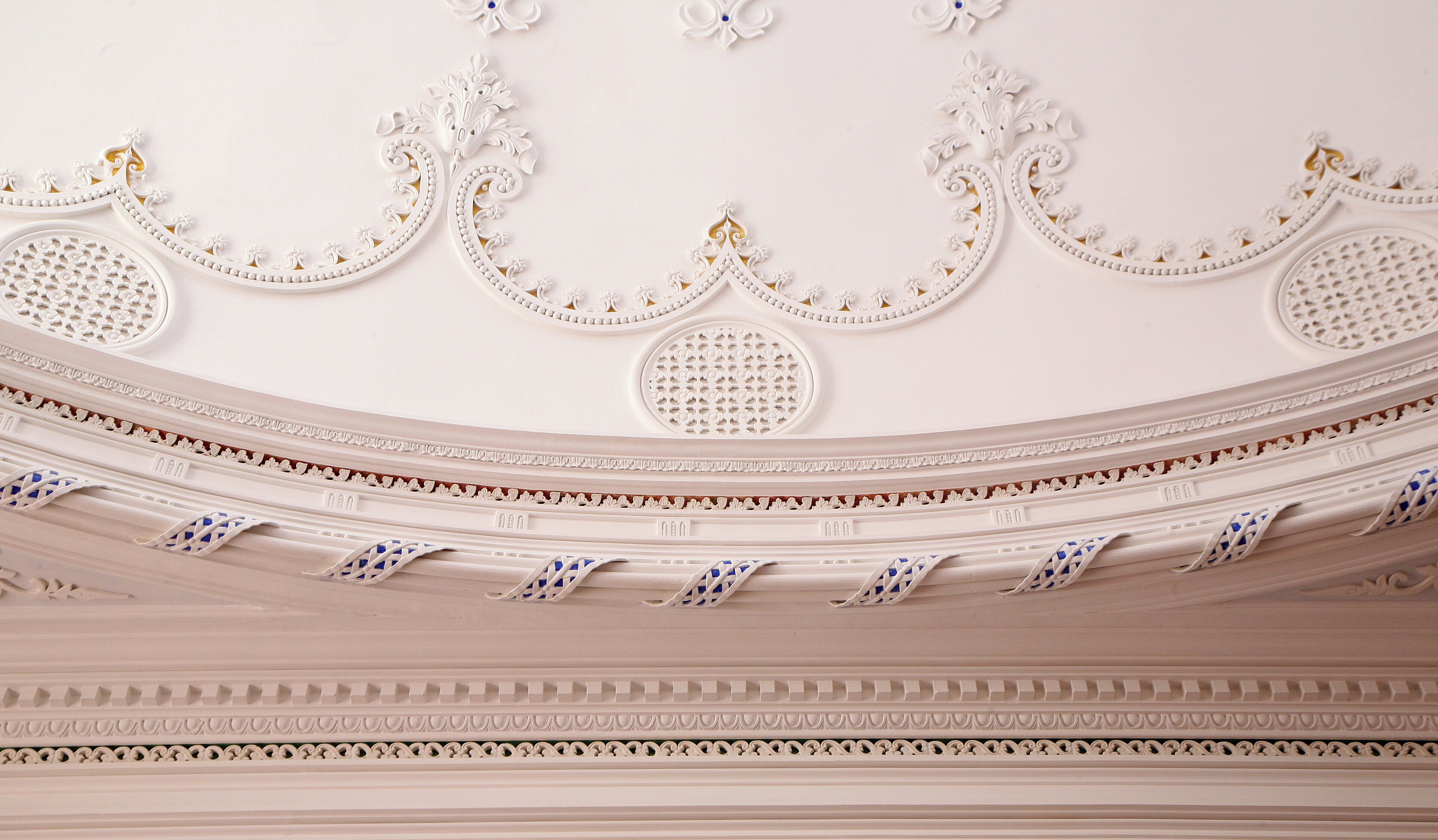 A detailed ceiling with ornate moldings and decorative elements.