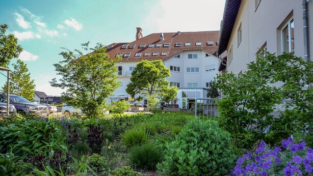 A residential building with a garden in front. - Hotel Café Nahetal (Gensingen)