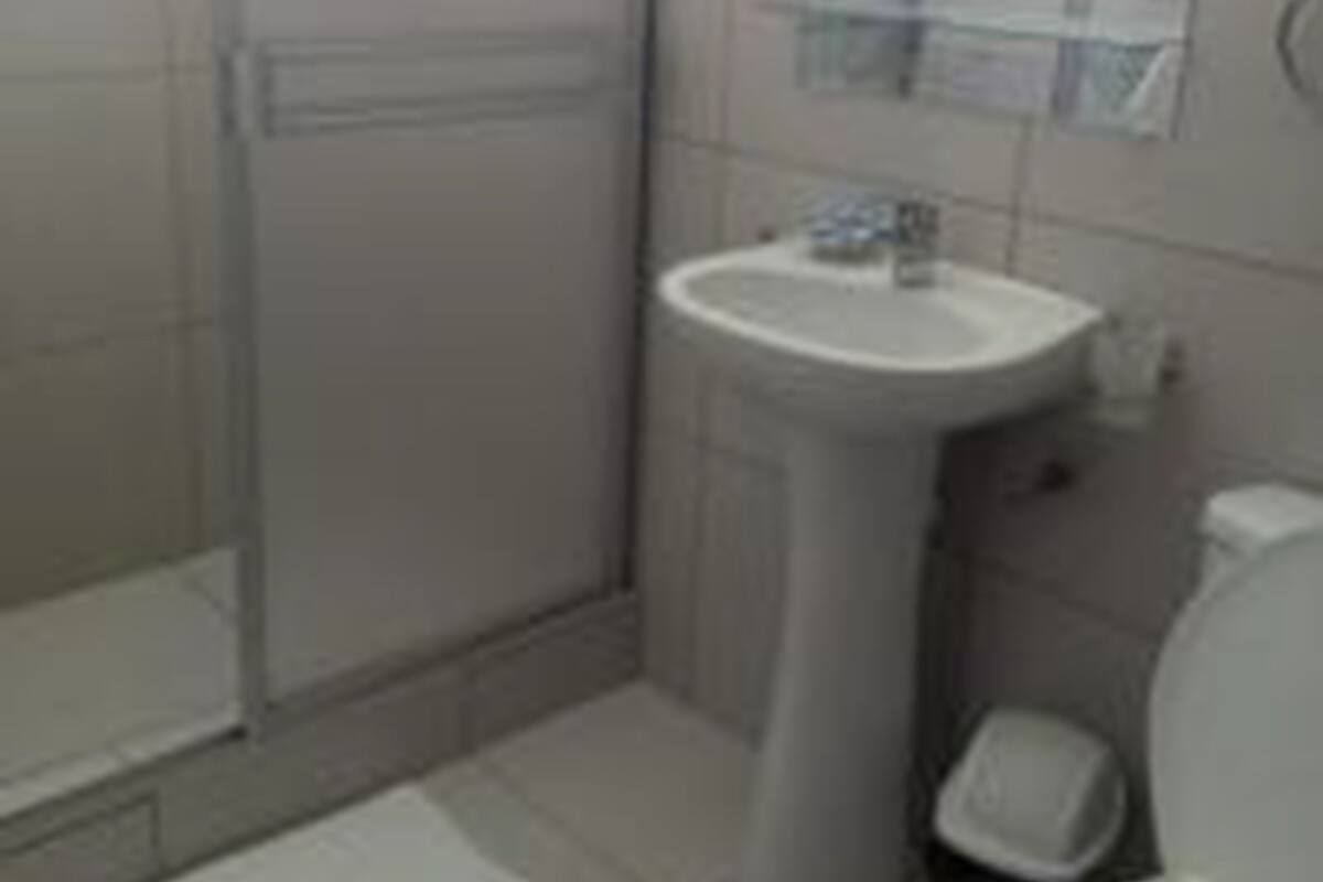 Un baño con ducha, lavabo e inodoro.