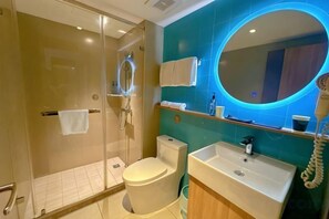 A modern bathroom with a glass-enclosed shower, a toilet, a sink, and a mirror with a blue-lit frame. - Ripple Hotel (Lianyungang Suning Plaza Pedestrian Street Food City) (Lianyungang)