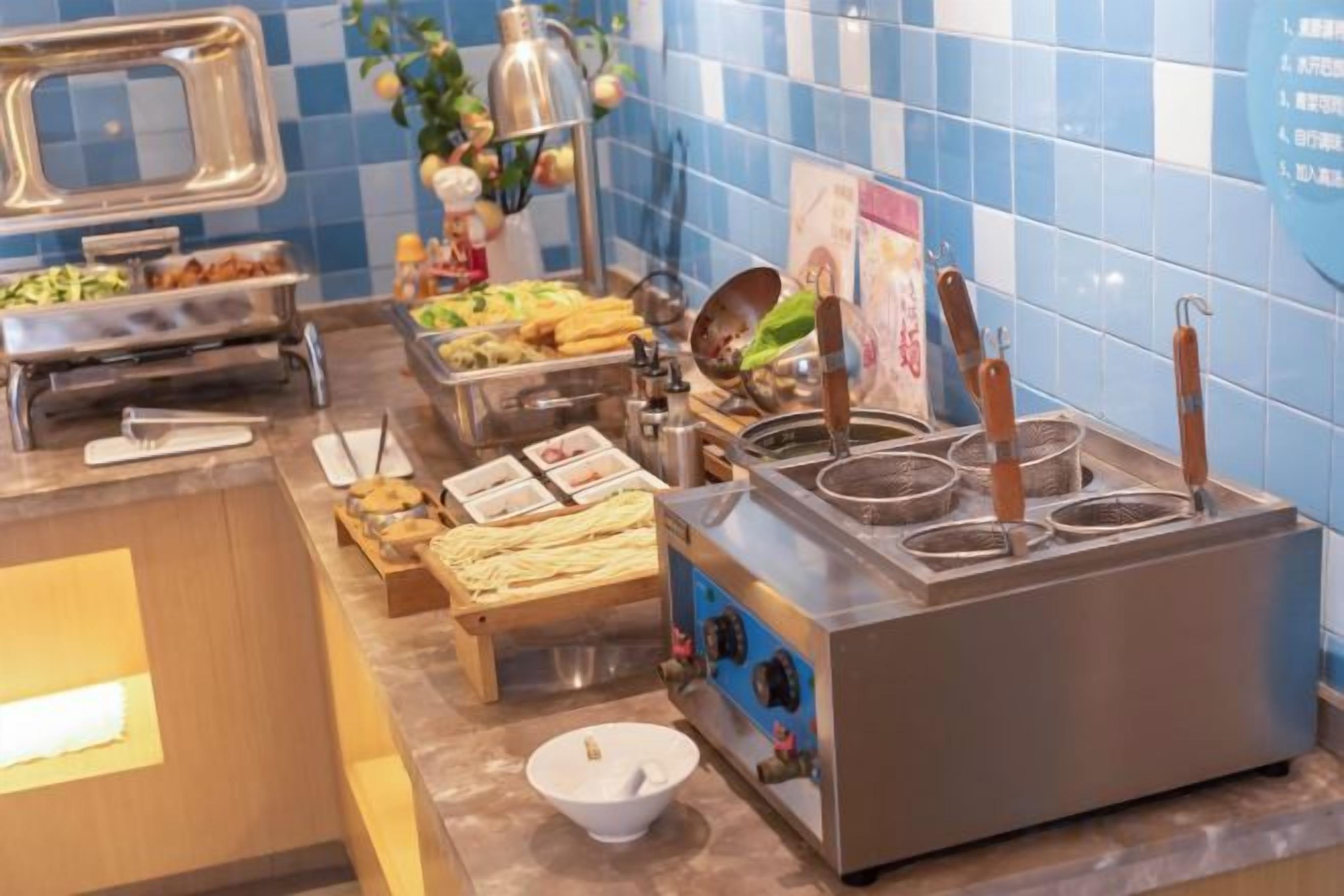 A buffet setup with various food items and cooking equipment.