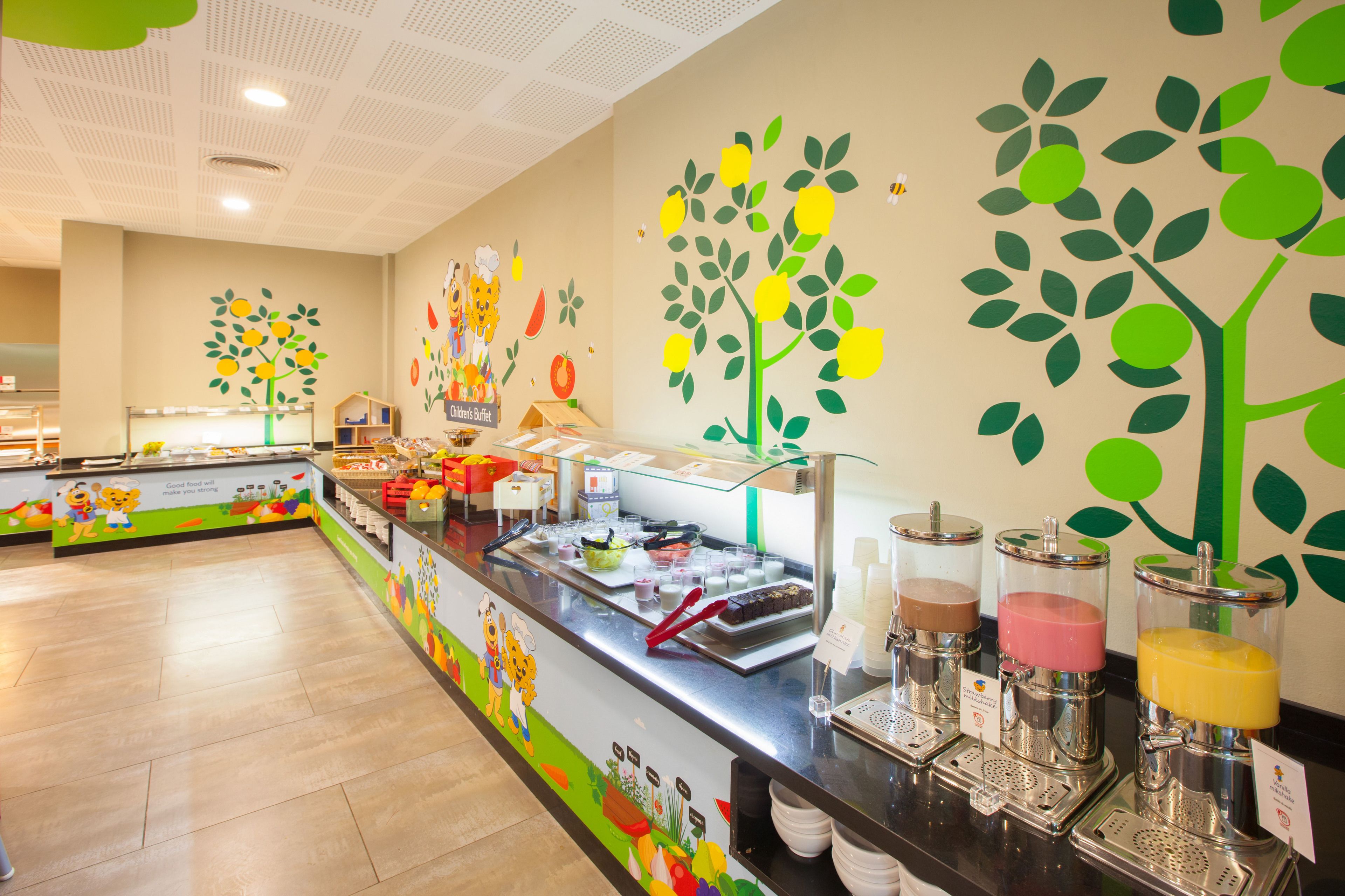 A buffet area with a variety of food items and drink dispensers.