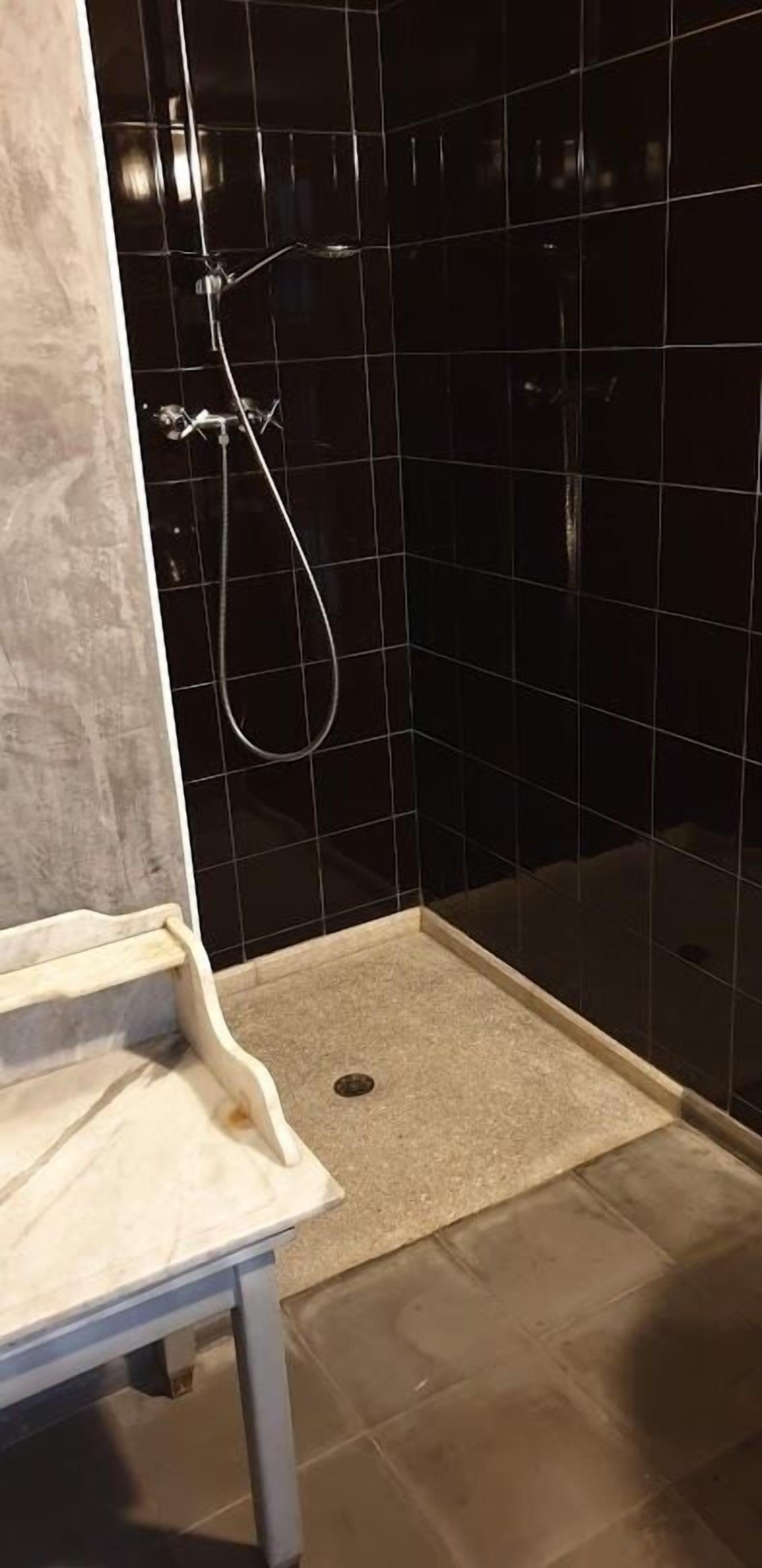 Une salle de bain comprenant un espace douche, un lavabo et des toilettes.