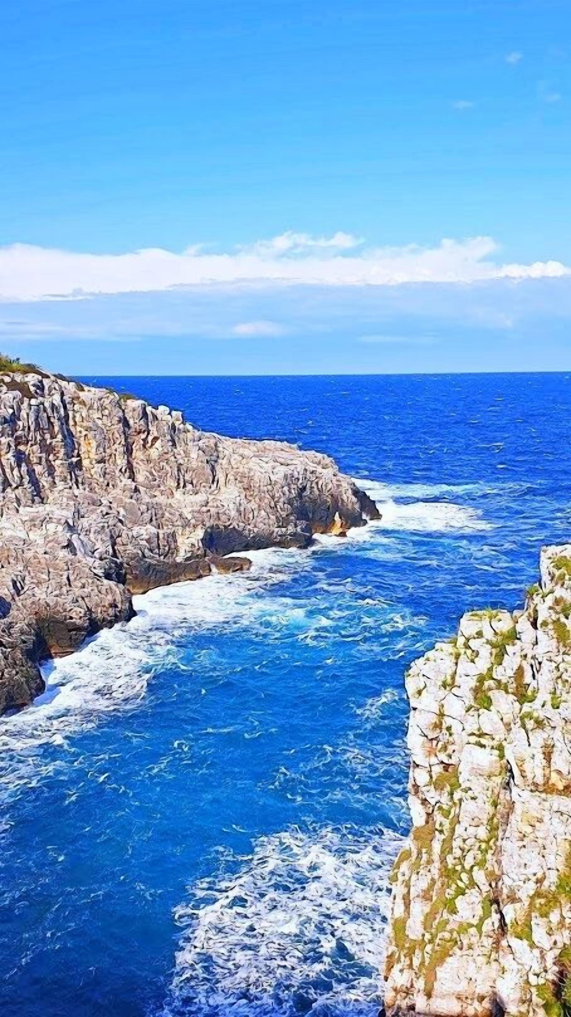 A coastal landscape with rocky cliffs and the ocean.