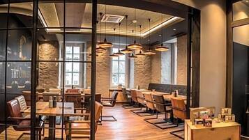 Ein Restaurant mit modernem Interieur, das Holztische und -stühle, Pendelleuchten und eine Wand aus Stein zeigt.