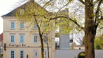 Ein Gebäude mit einem Schild, auf dem 'Cippicher Hof' steht, und einem Baum im Vordergrund.