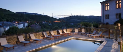 Una piscina al aire libre de temporada, sombrillas, tumbonas