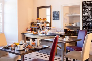 A breakfast buffet with various food items and beverages, a coffee station, and seating arrangements. - Château de Creissels (Creissels)