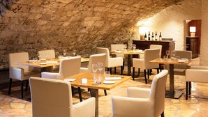A restaurant with stone walls and tables set for dining. - Château de Creissels (Creissels)