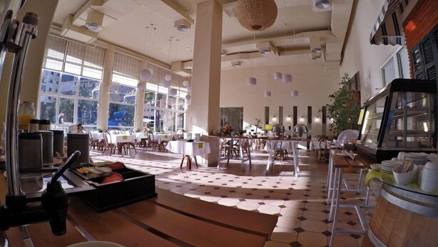 Un comedor amplio con techos altos, ventanas grandes y una isla central.