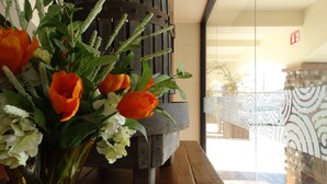 Una mesa de madera con un florero y un farol rústico.