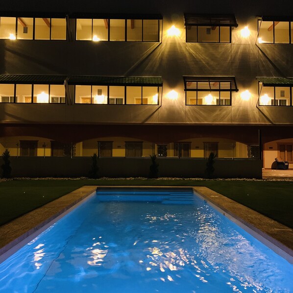 Un edificio con varias ventanas y una piscina delantera.