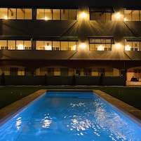Un edificio con varias ventanas y una piscina delantera.