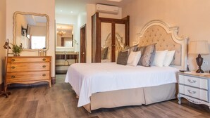 Un dormitorio con una cama grande, cómoda de madera y un espejo.