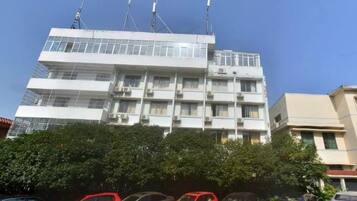 Un edificio de varios pisos con balcones y unidades de aire acondicionado.
