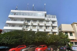 A multi-story building with balconies and air conditioning units. - Ganzhou Hotel (Ganzhou)