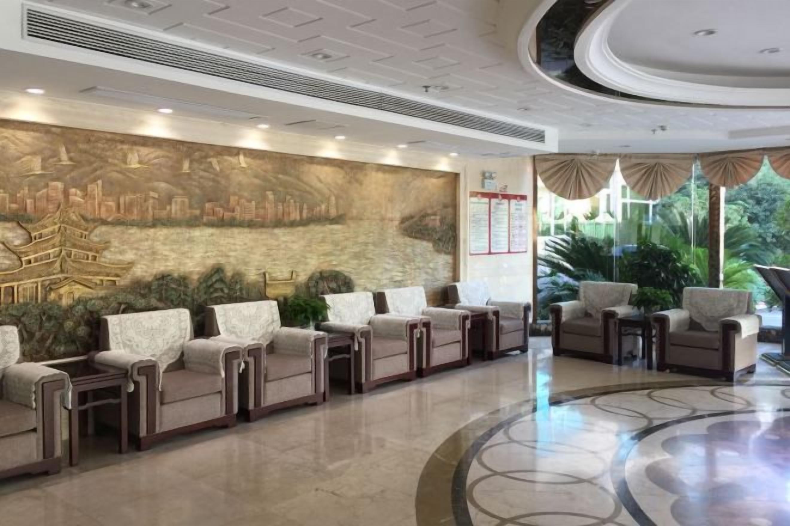 A hotel lobby with a reception desk, seating area, and a mural.