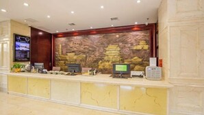 Una recepción con una pantalla digital, una computadora y un teléfono.