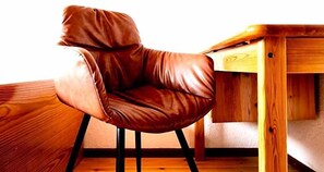 A brown leather chair with a wooden desk and a wooden floor. - Hotel Nest (Berlin)
