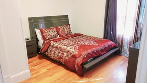 A bedroom with a bed, nightstands, and a wooden floor. - Upscaled Home in a Quiet Neighborhood (Springfield)