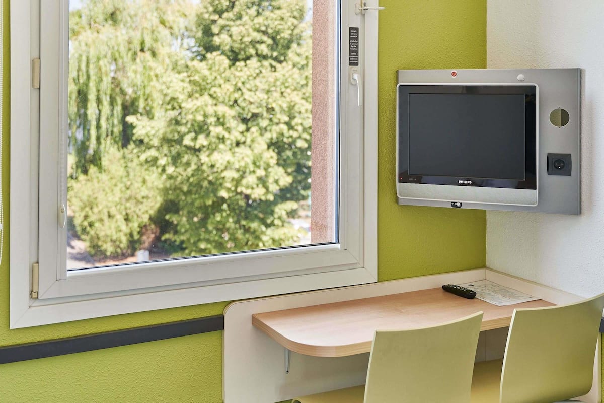 Escritorio, cortinas blackout y tabla de planchar con plancha