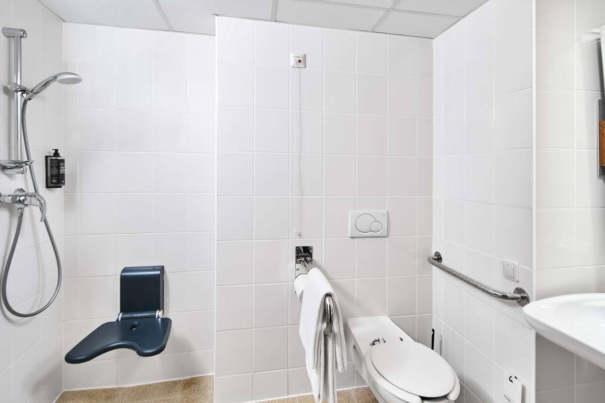 A modern bathroom with a shower, toilet, and sink.