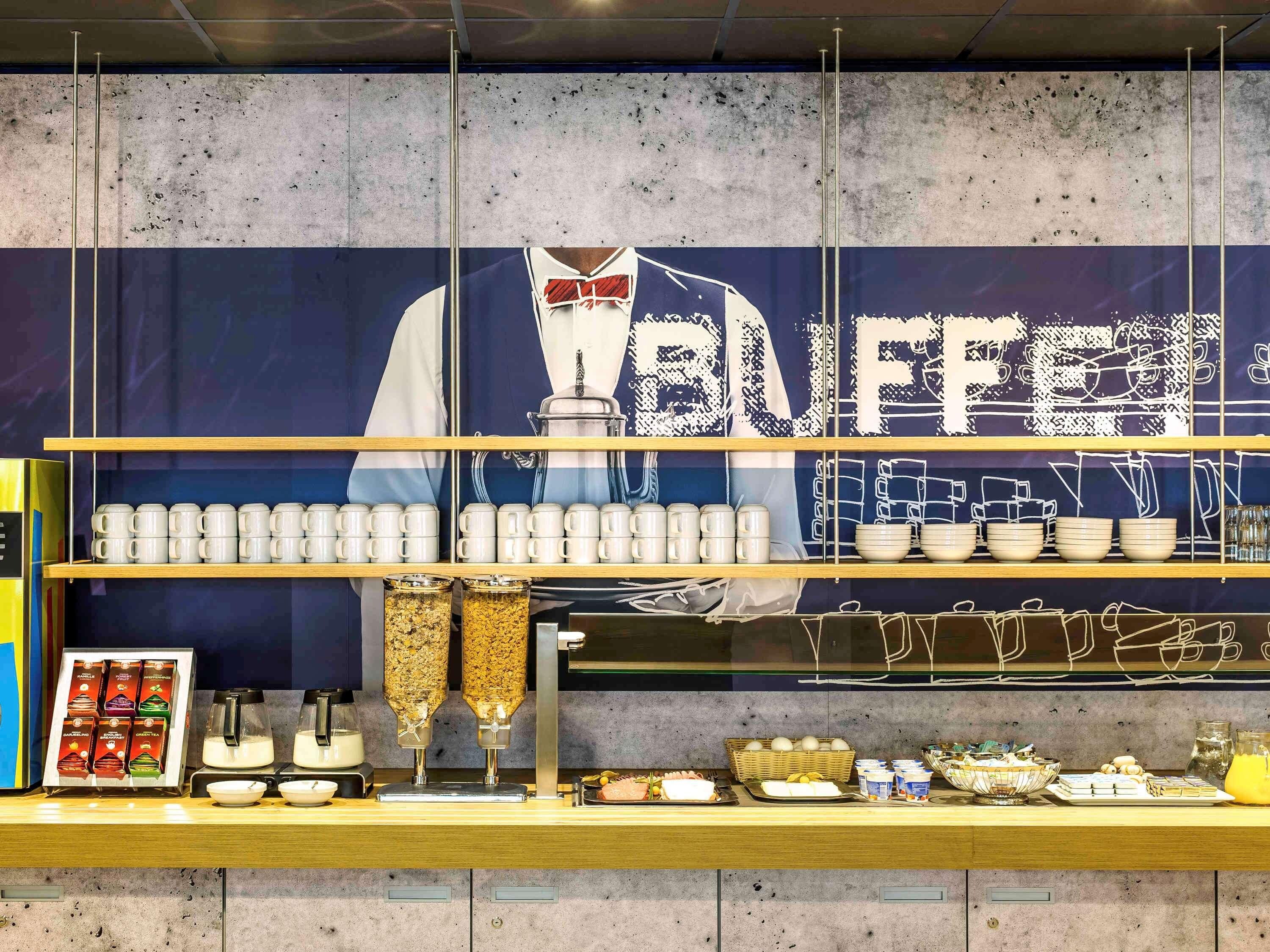 Mostrador de buffet con diversos alimentos y una máquina de café.