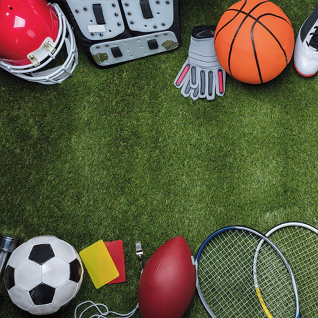 On peut voir une variété d’équipements de sport, notamment un ballon de football, un ballon de basket, un ballon de football américain et des raquettes de tennis, sur une surface verte.