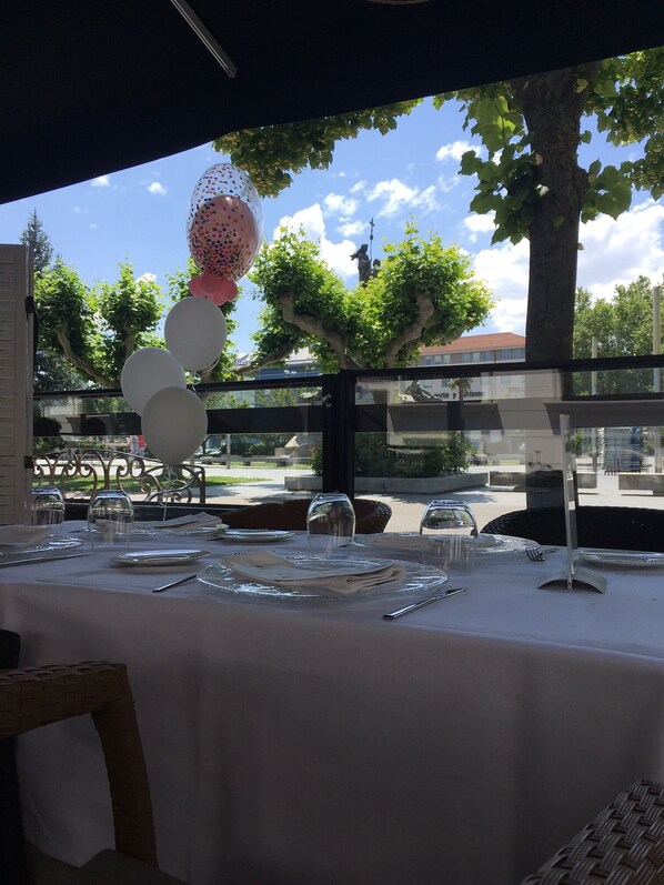 Mesa lista para comer con vista a árboles y una estatua.