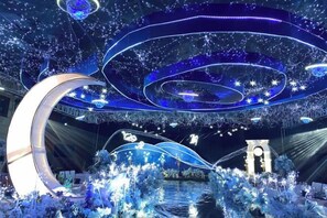 A modern interior with a circular architectural feature, a water body, and decorative lighting. - Huaqiao Hotel (Yingtan)