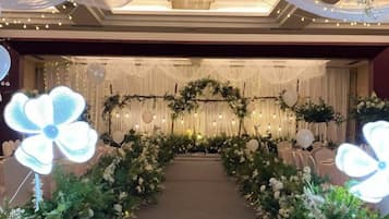 A decorated aisle with floral arrangements and a chandelier.