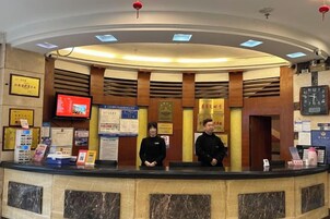 A reception desk with a marble counter, framed certificates, a clock, and informational posters.
