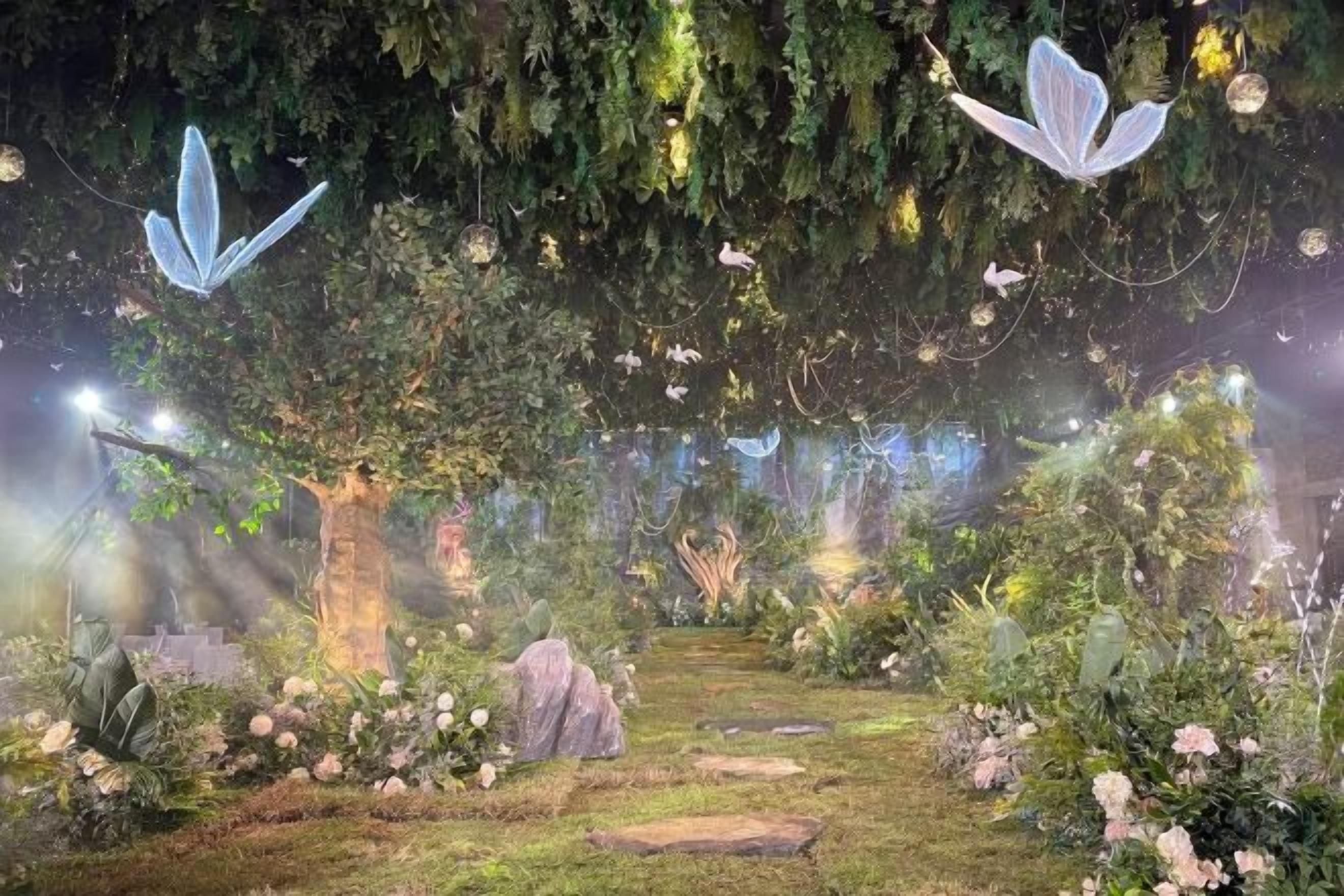 A garden with a pathway, trees, and hanging lights.