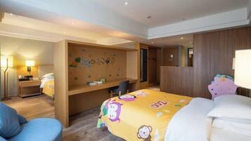 A hotel room with a bed, a desk, a chair, and a wall with a decorative mural.