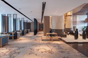 A hotel lobby with a reception desk, seating area, and decorative elements. - Shengxiao Grand Hotel (Quzhou Airport) (Quzhou)