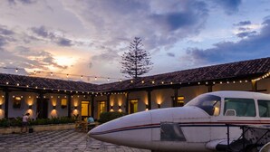 An airplane parked in a courtyard with a building in the background. - Lemon Tree Hostel (Antigua Guatemala)