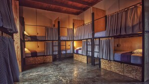 A dormitory-style room with bunk beds, wooden flooring, and a rustic ceiling. - Lemon Tree Hostel (Antigua Guatemala)