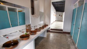 A corridor with a row of blue lockers and a long bench with ceramic bowls. - Lemon Tree Hostel (Antigua Guatemala)
