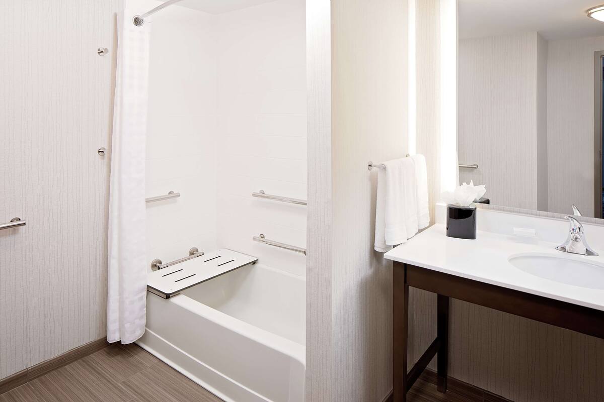 Ein modernes Badezimmer mit Badewanne, Waschbecken und Spiegel.