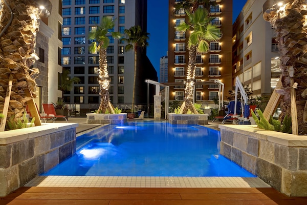 Una piscina al aire libre, sillones reclinables de piscina