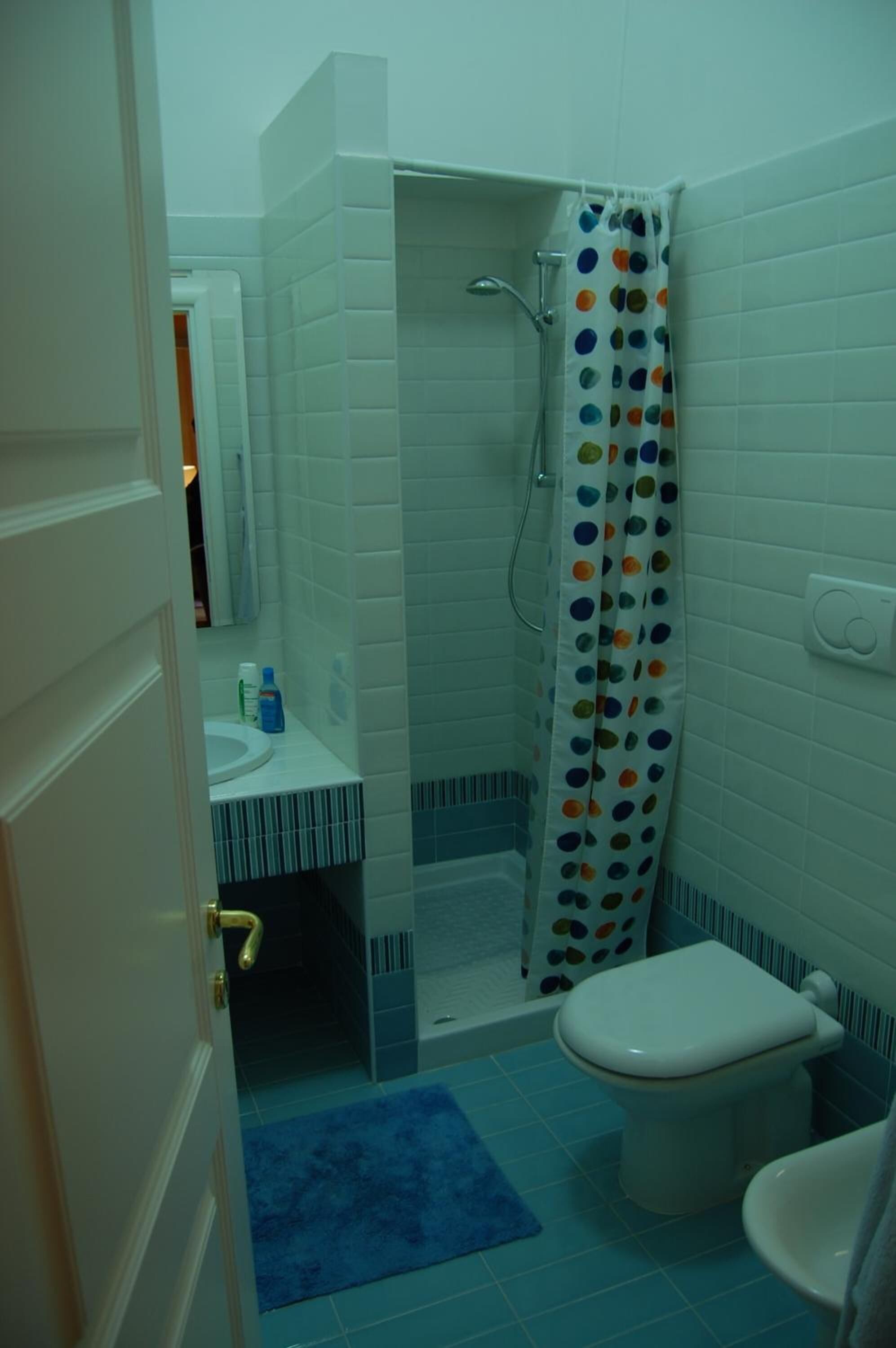 A bathroom with a shower, toilet, and sink.