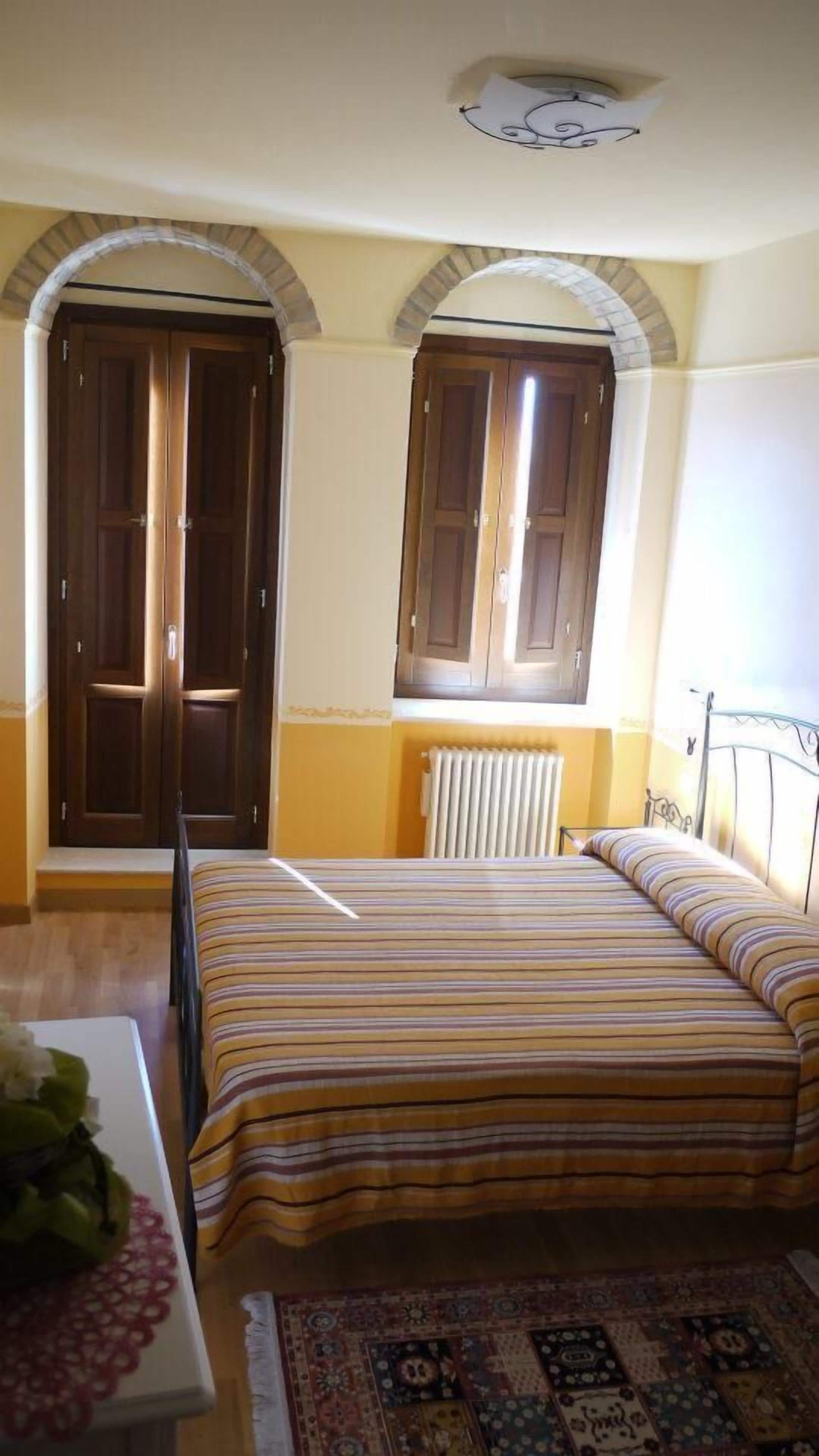 Une chambre à coucher avec un lit, un radiateur et deux portes.