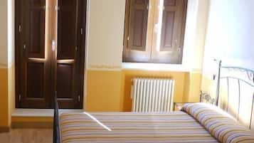 Une chambre à coucher avec un lit, un radiateur et deux portes.