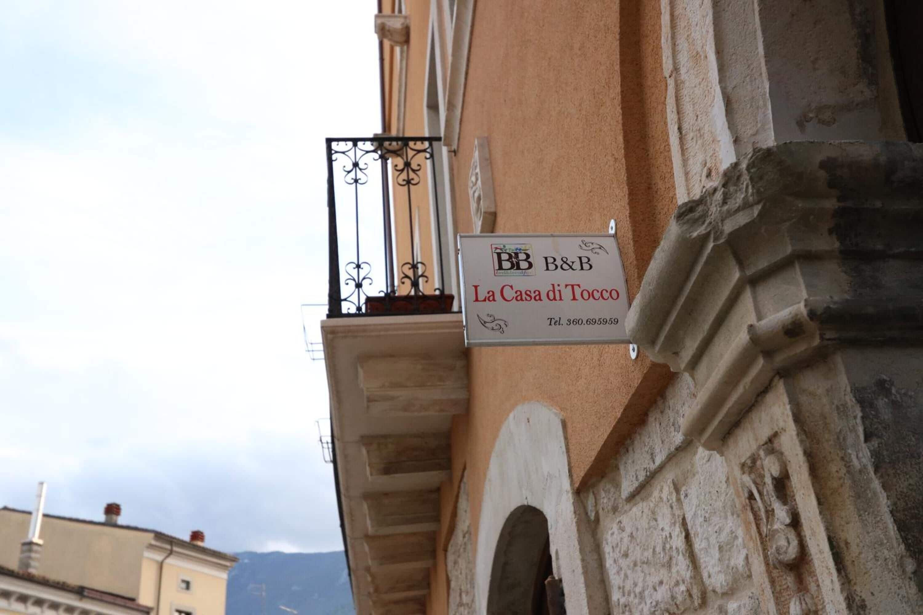 A sign for 'BB B&B La Casa di Tocco' with a telephone number.