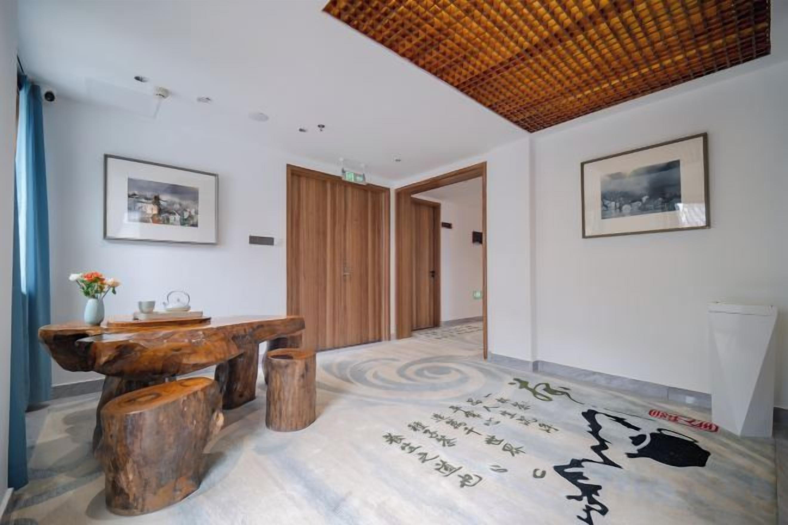 A reception area with a wooden bench, a vase with flowers, and framed pictures on the walls.